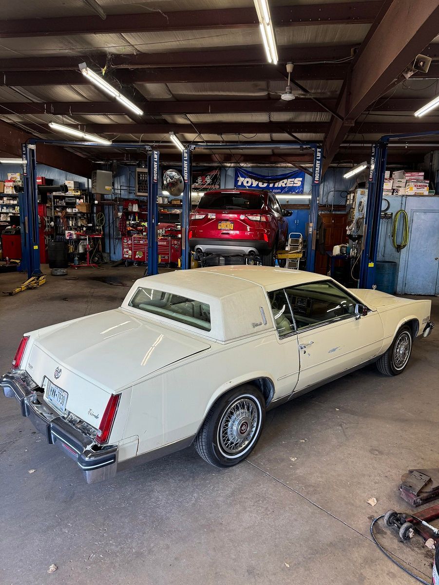 White Cadillac Eldorado in an auto repair shop.