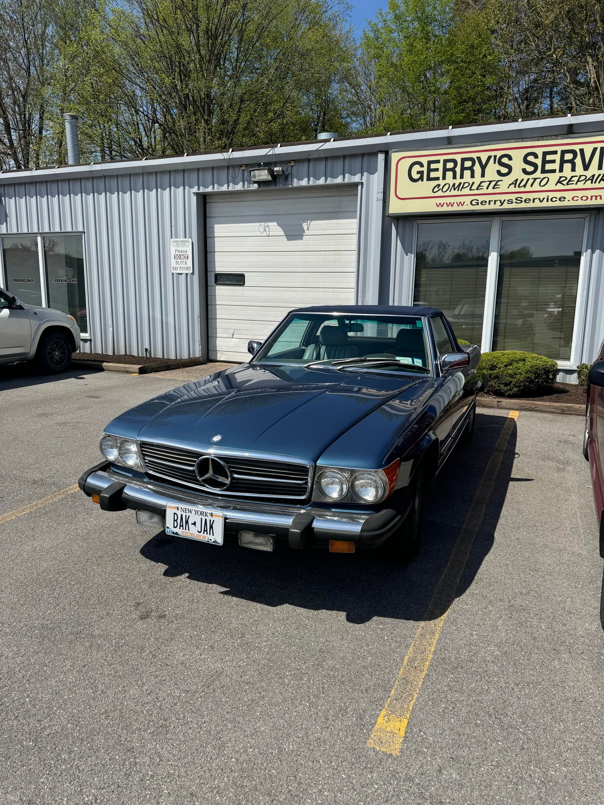 Blue Mercedes-Benz convertible parked in front of 