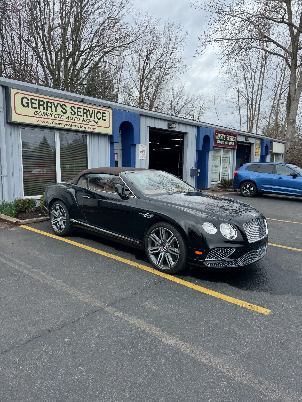 Black Bentley convertible parked in front of Gerry's Service garage.