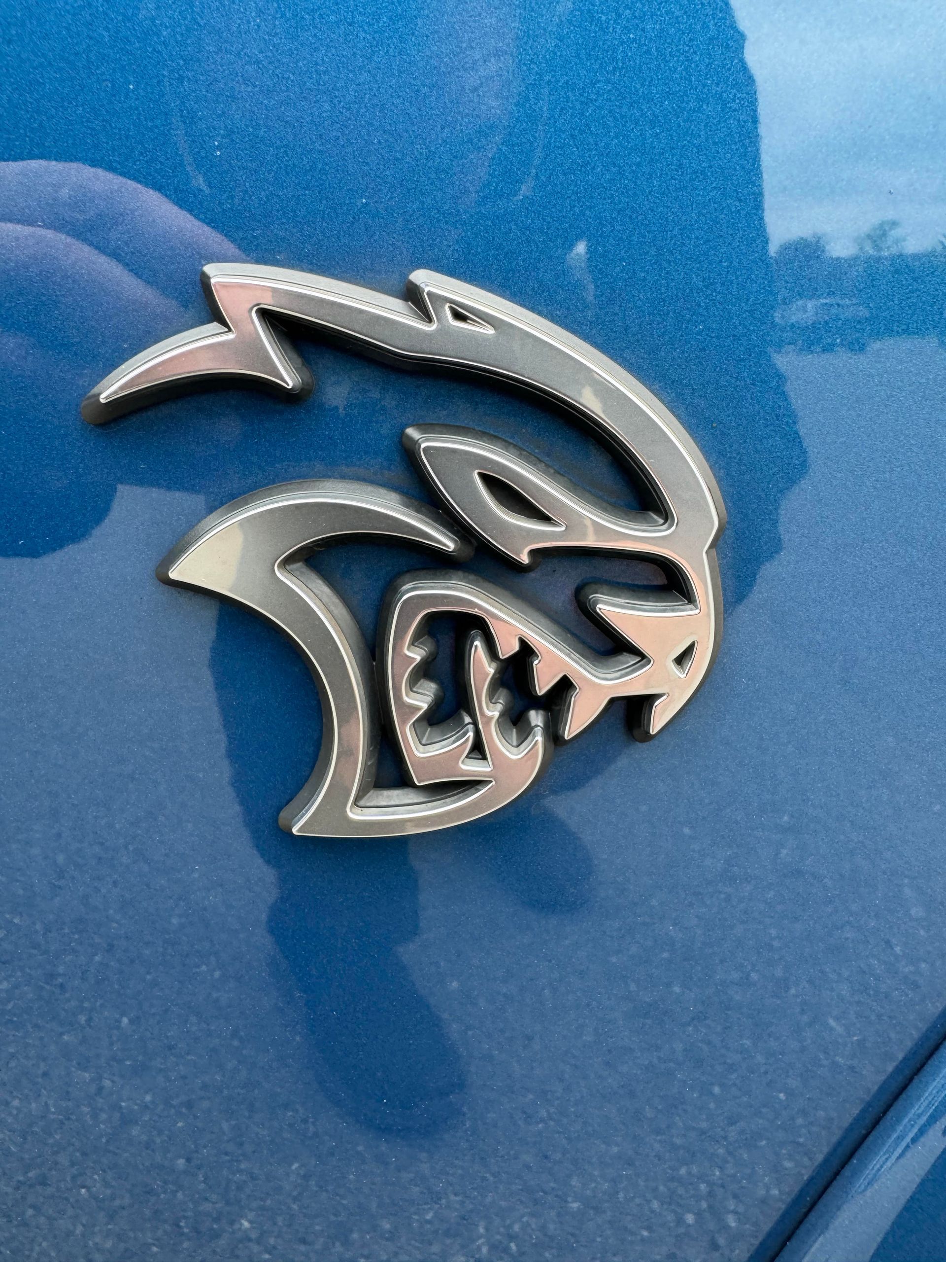 Silver Hellcat logo on a blue car.