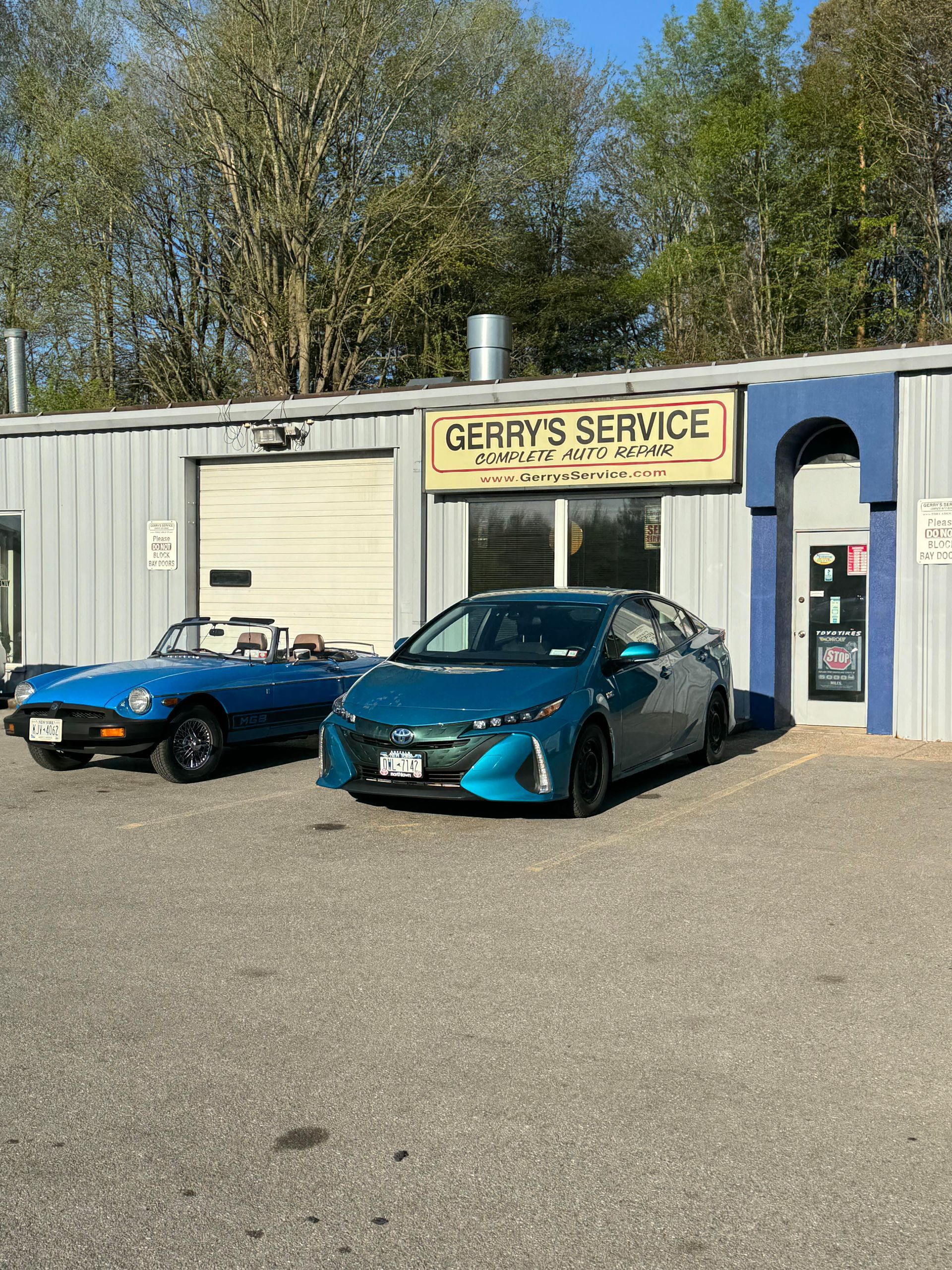 Gerry's Service garage with a blue convertible and a teal Prius parked in front.