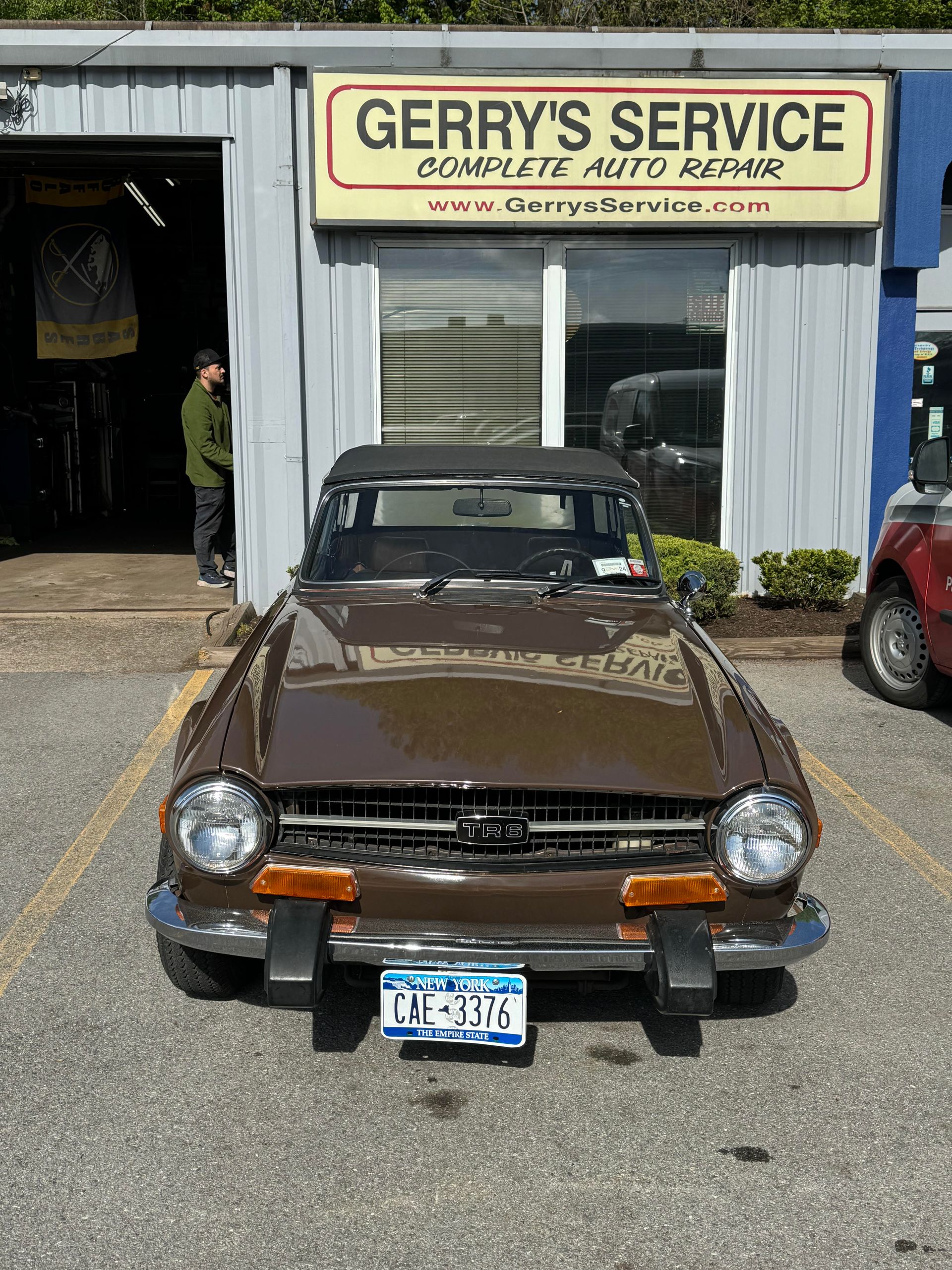 Brown convertible sports car parked in front of 