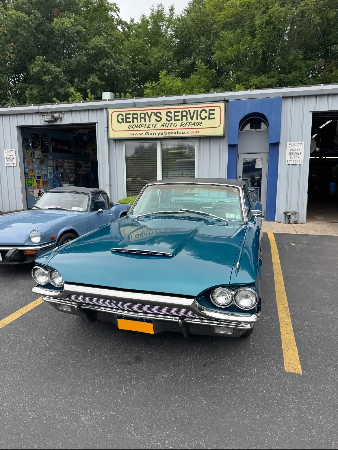 Teal classic car parked in front of