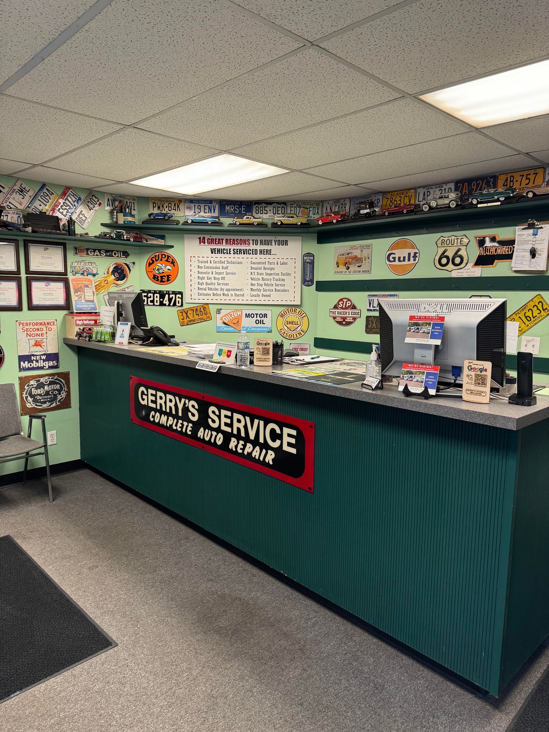 Inside of Terry's Service auto repair shop, a dark green counter with the shop's name, display items, and a white board.
