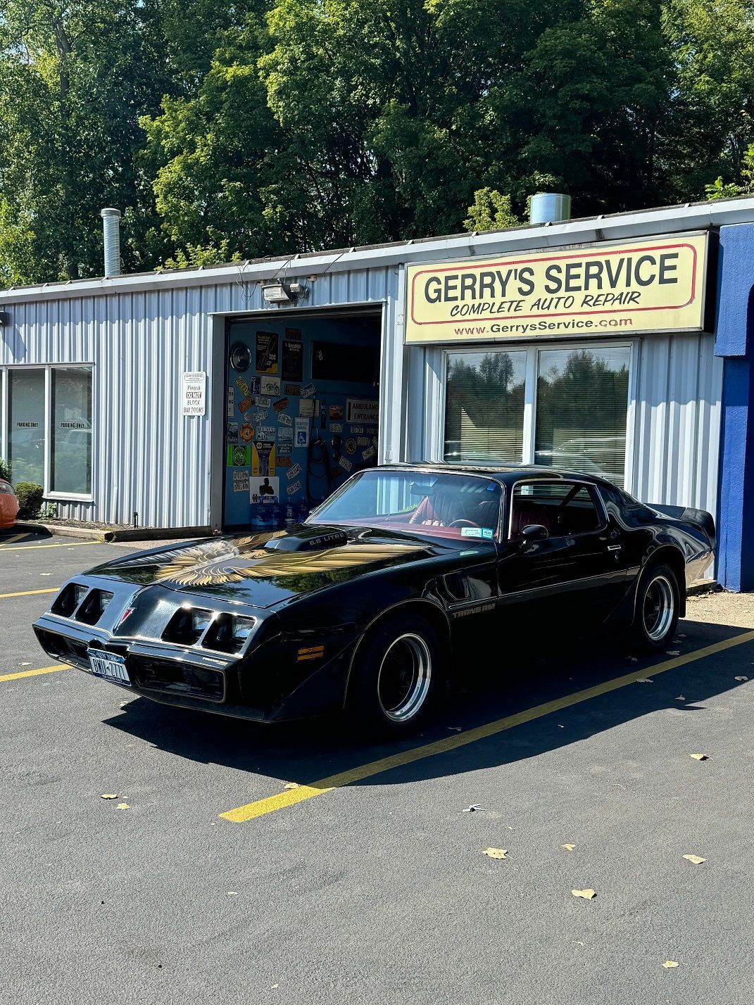 Black Pontiac Firebird Trans Am parked in front of 
