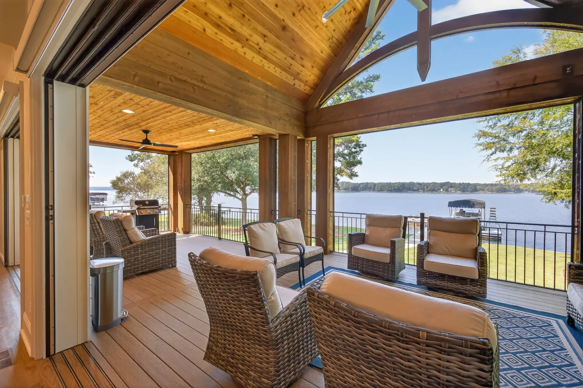 Covered outdoor living room opening to a lake view in Reynolds Lake Oconee
