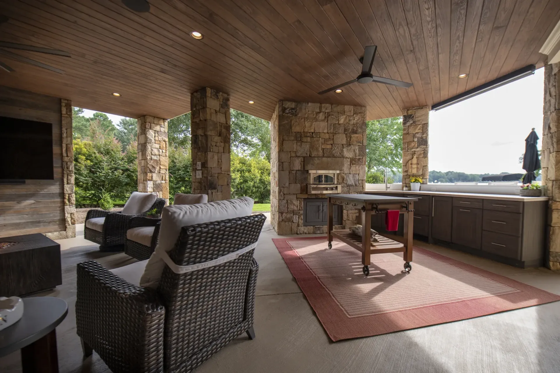 Two-level covered outdoor living addition with stone columns in Cuscowilla