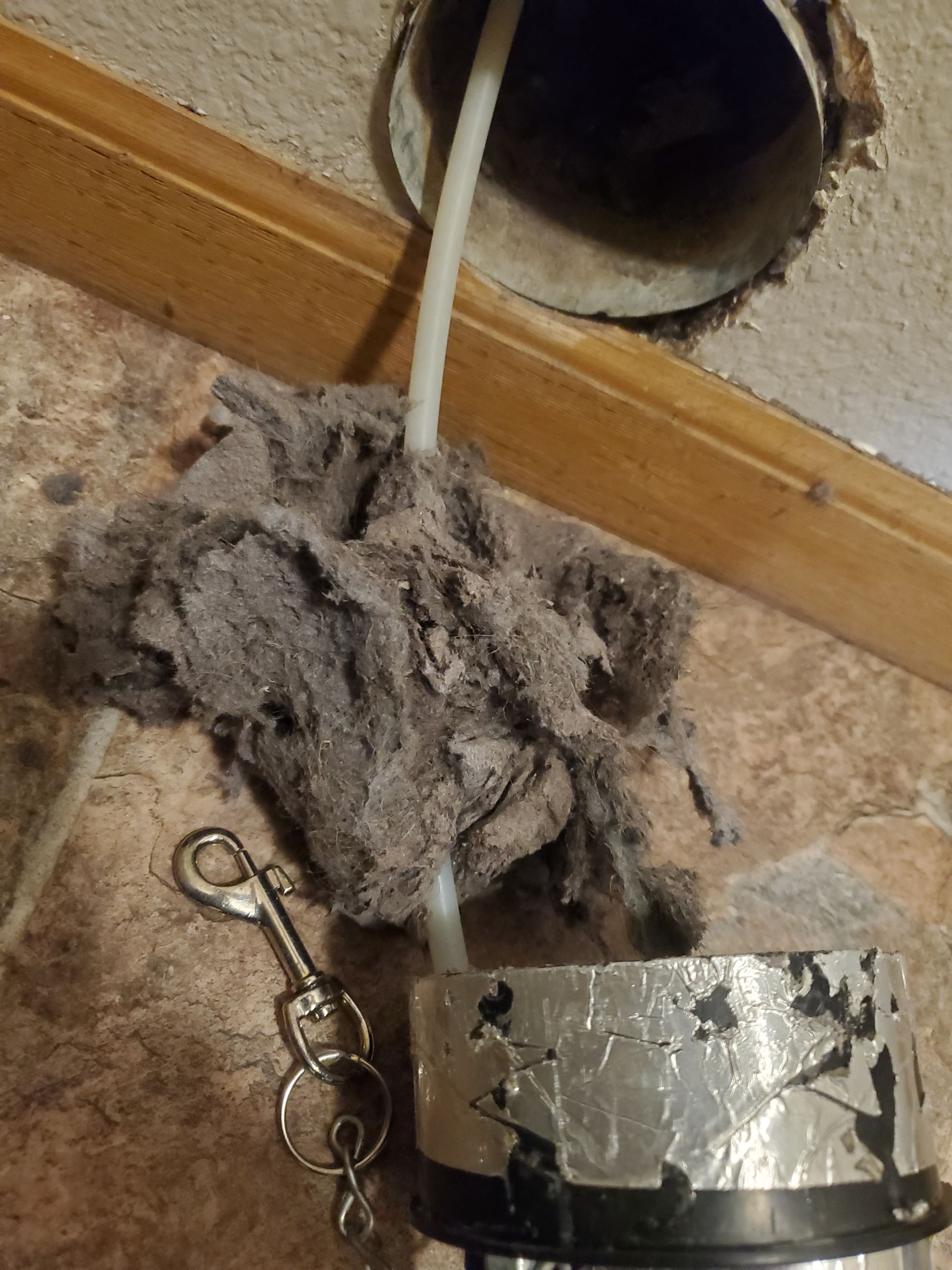 A bunch of dust is coming out of a hole in the ceiling.