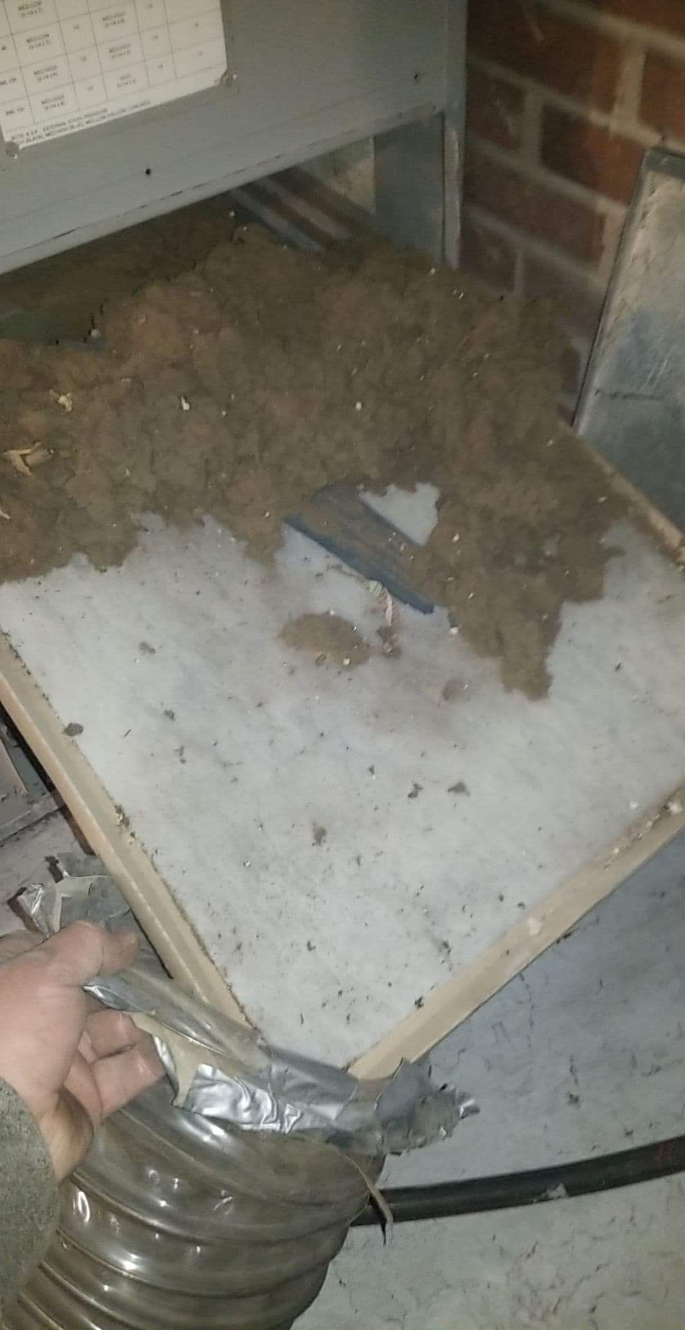 A person is cleaning a duct with a vacuum cleaner.