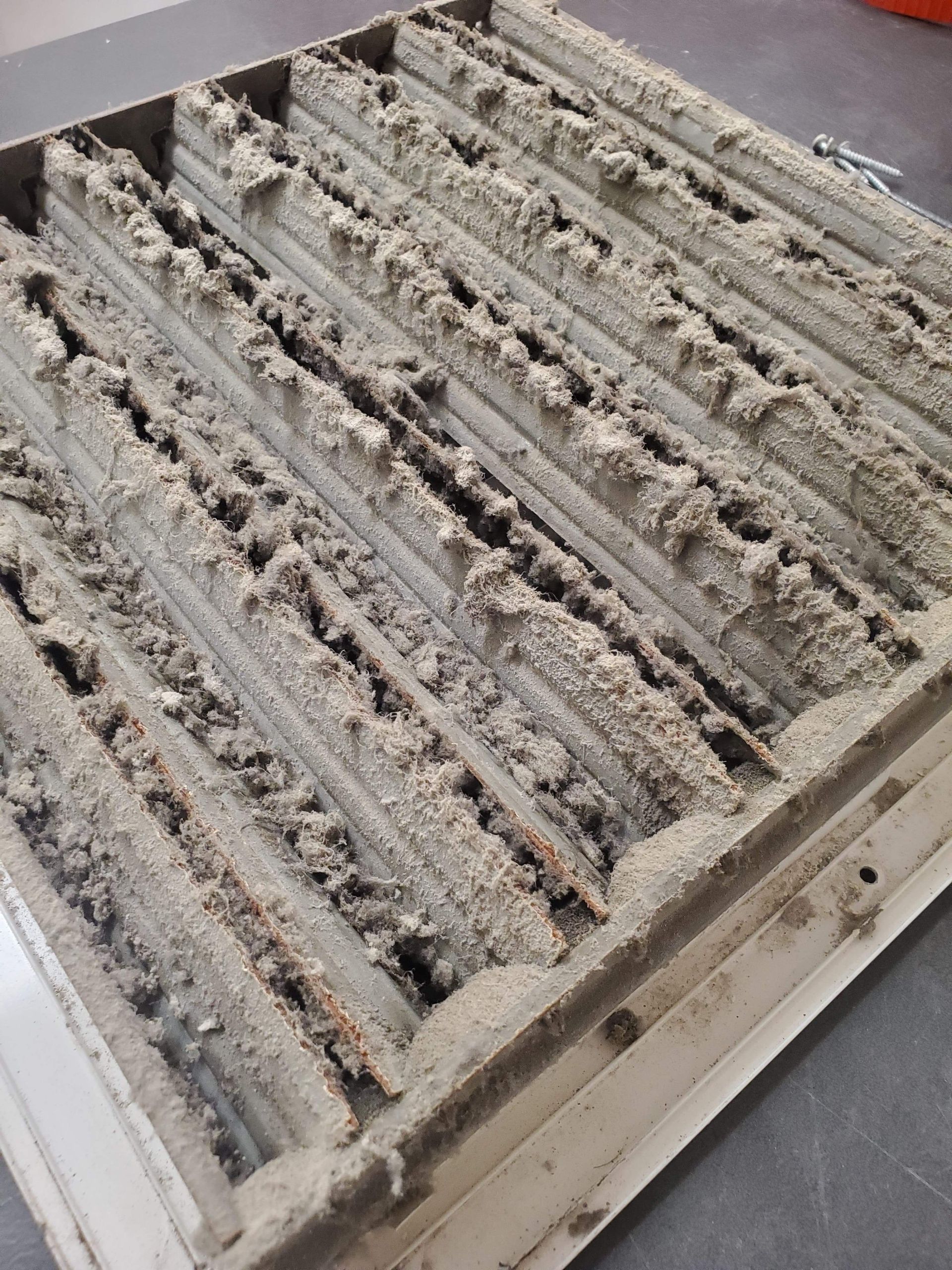 A dirty air vent is sitting on a table.