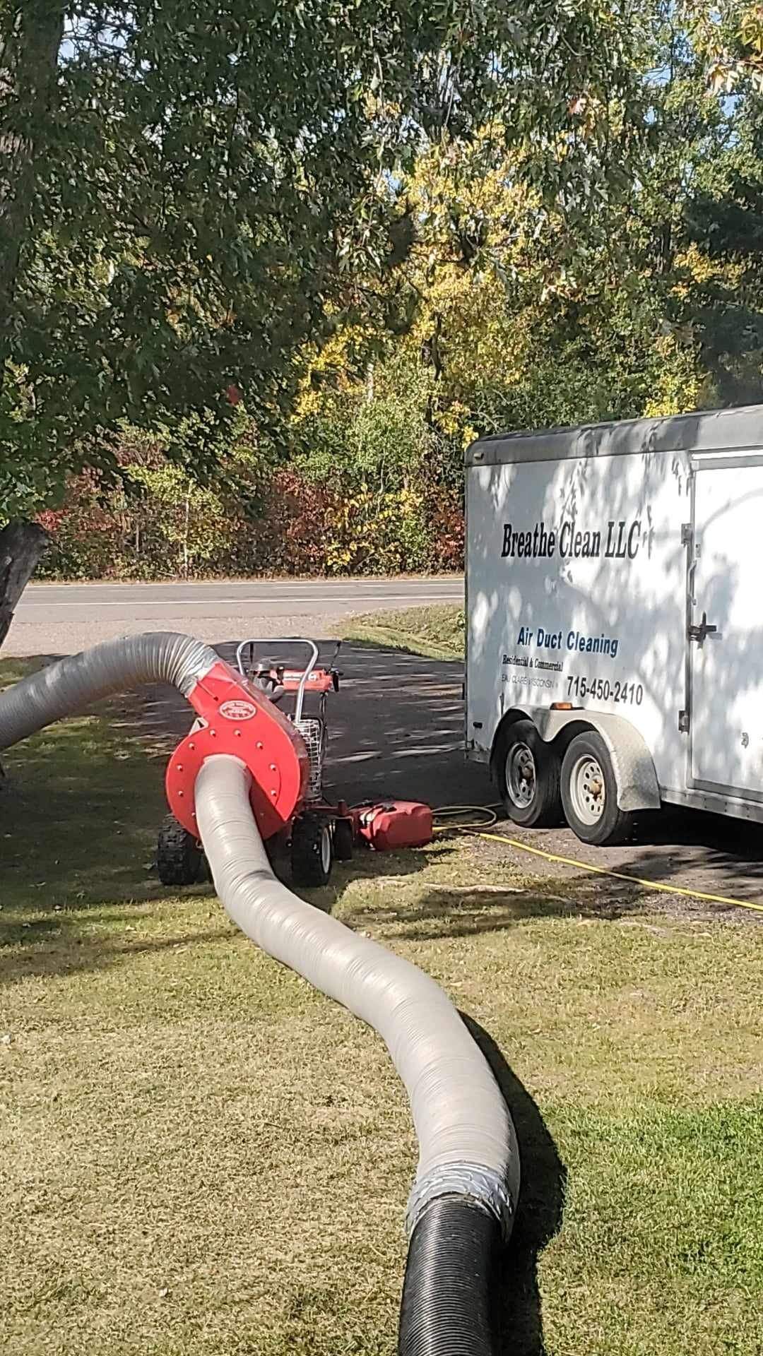 A vacuum cleaner is attached to a trailer in a yard.