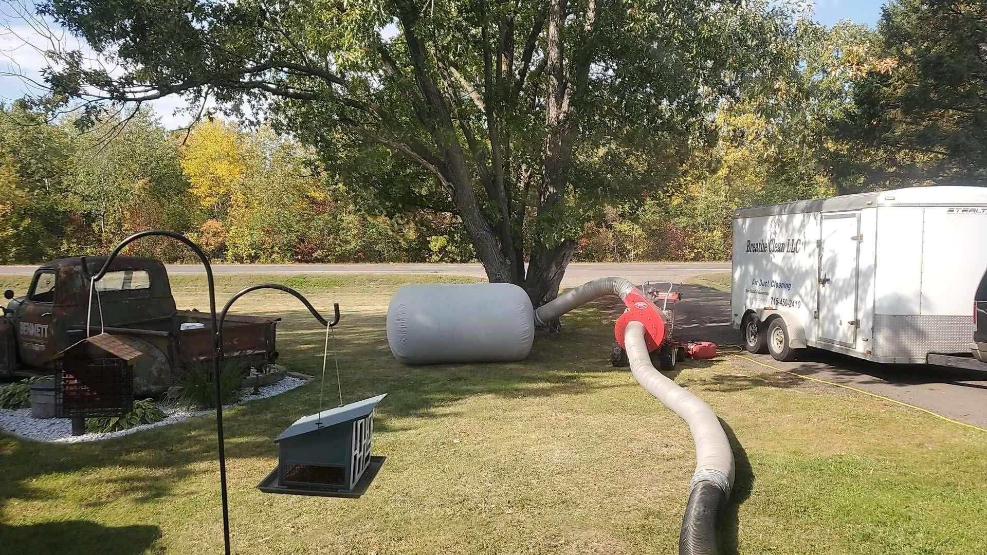 A vacuum cleaner is sitting on the grass next to a truck.