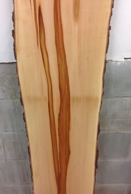 a large piece of wood against a brick wall