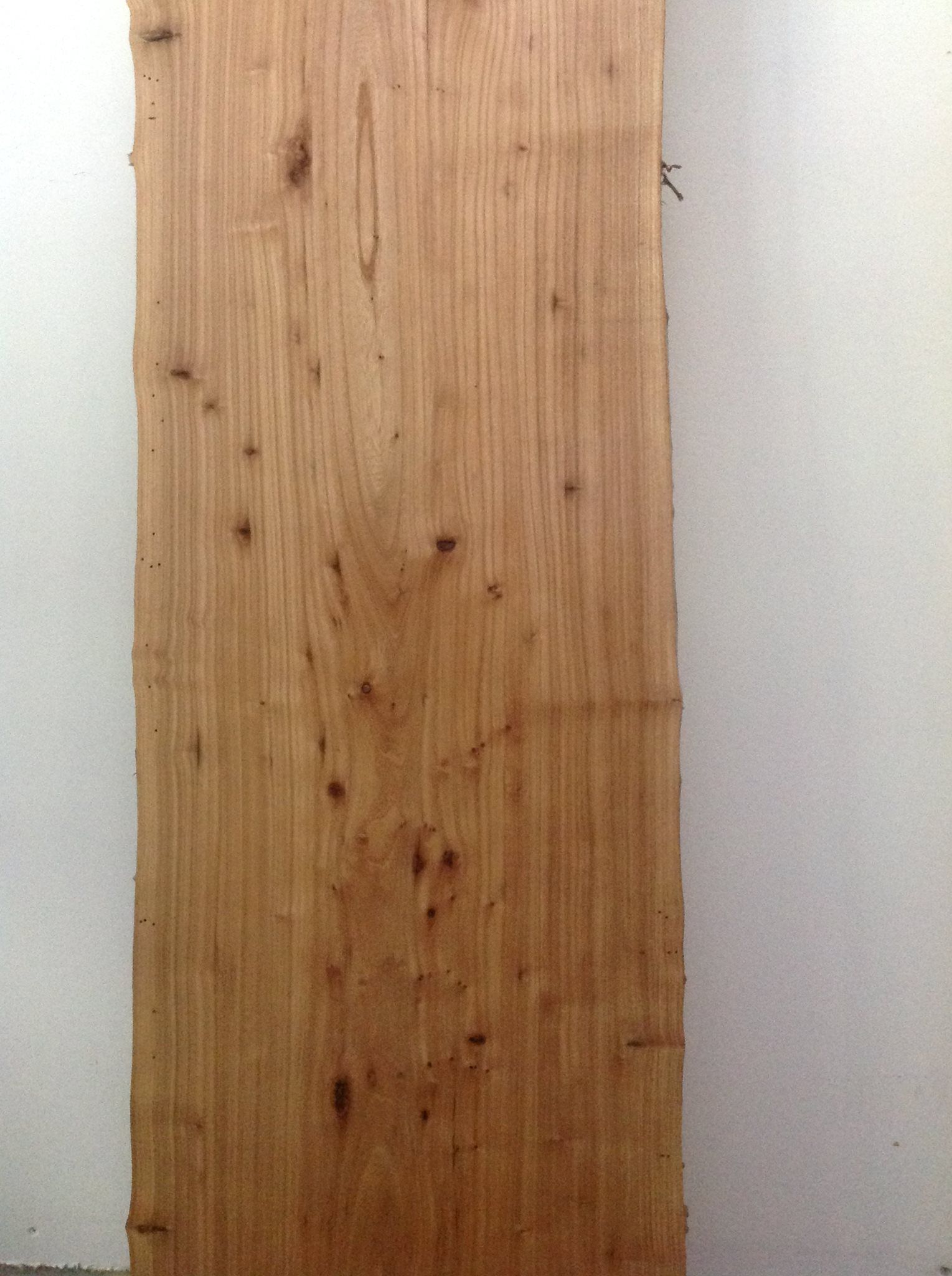 a large piece of wood against a brick wall