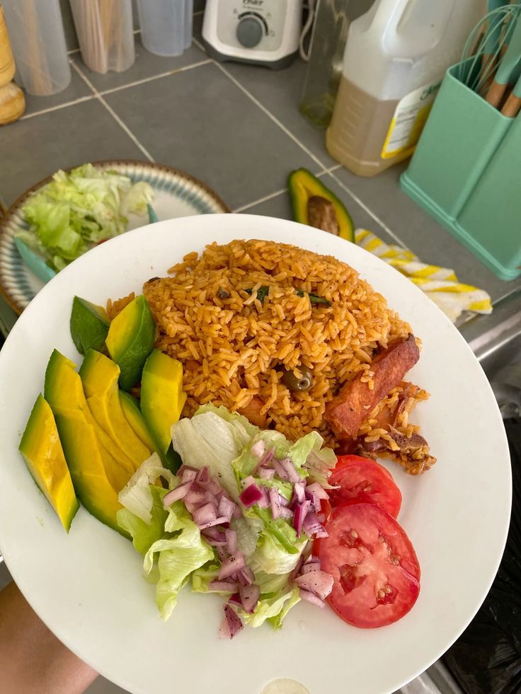 Plate of food: rice, avocado, chicken, salad, tomato.