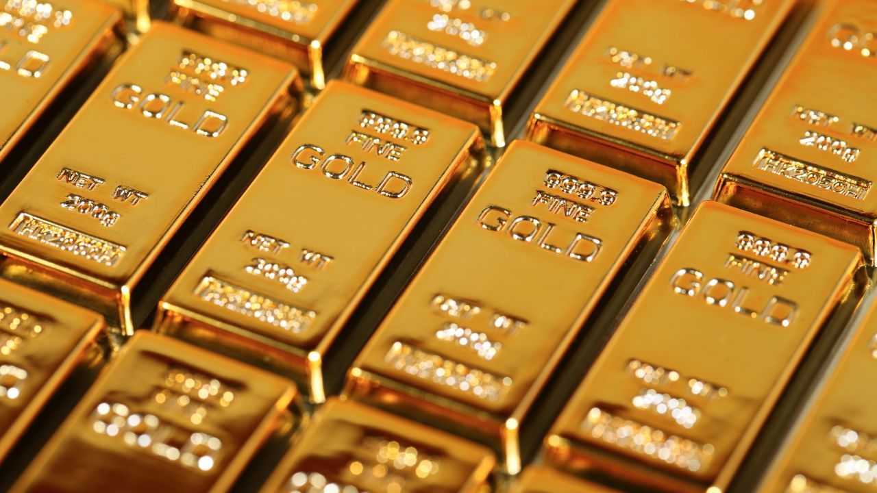 A bunch of gold bars stacked on top of each other on a table.