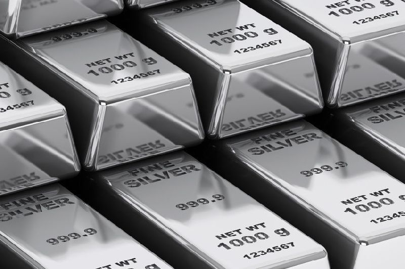 A bunch of silver bars stacked on top of each other on a table.