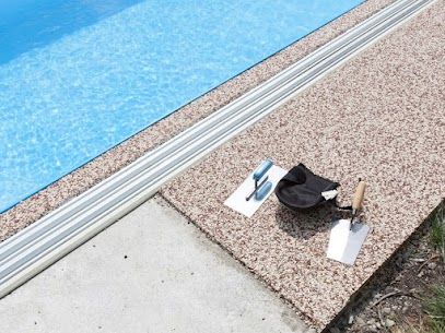 Two Trowel And A Bag Are Sitting On A Concrete Surface Next To A Swimming Pool  — River2Coast Concreting in Boambee, NSW