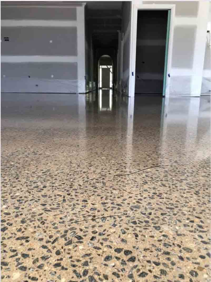 A Shiny Concrete Floor In A Room With A Door In The Background — River2Coast Concreting in Boambee, NSW
