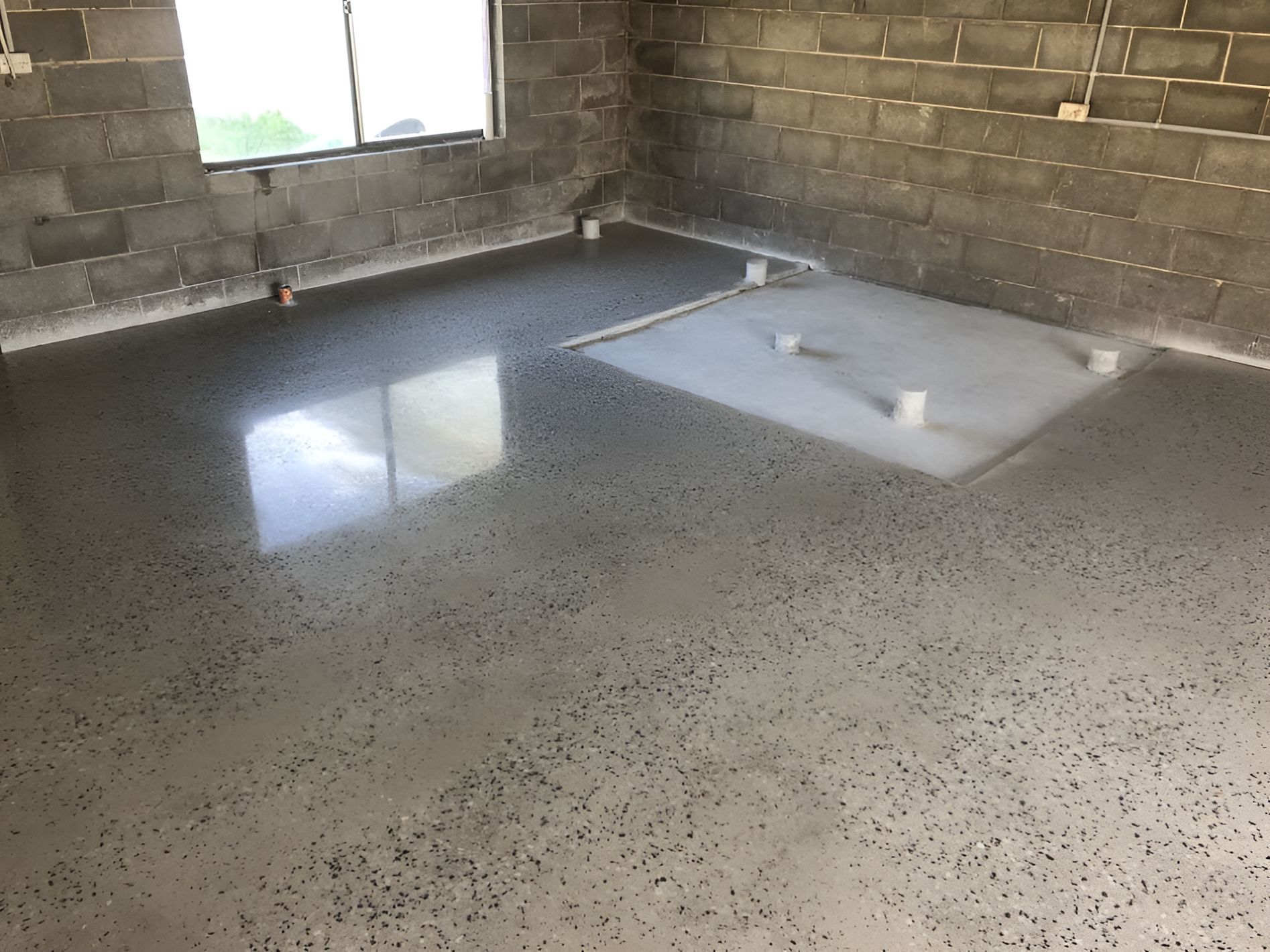A Room With A Concrete Floor And Brick Walls — River2Coast Concreting in Boambee, NSW