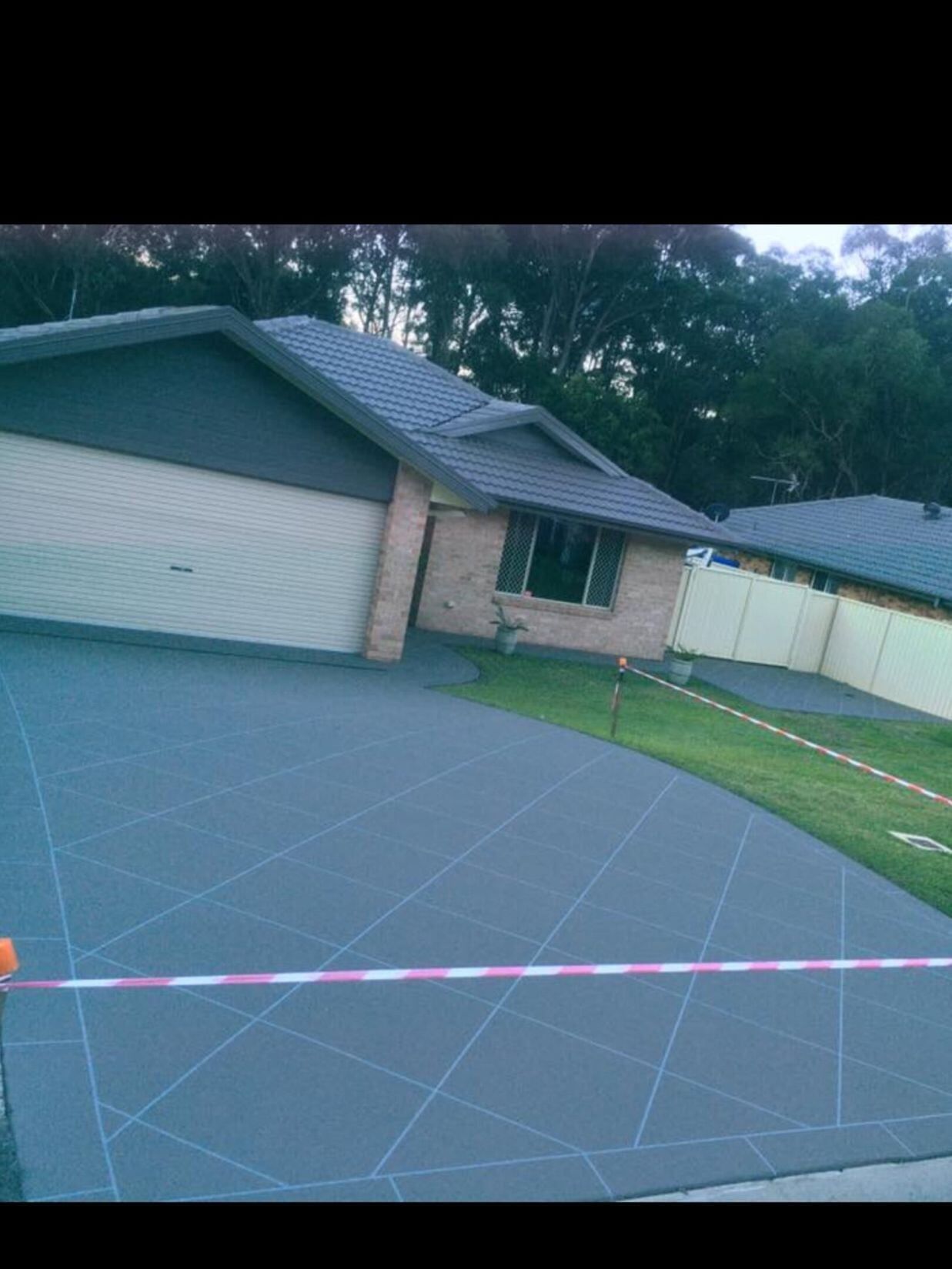 A Driveway Leading To A House With A Fence And Trees In The Background  — River2Coast Concreting in Grafton, NSW