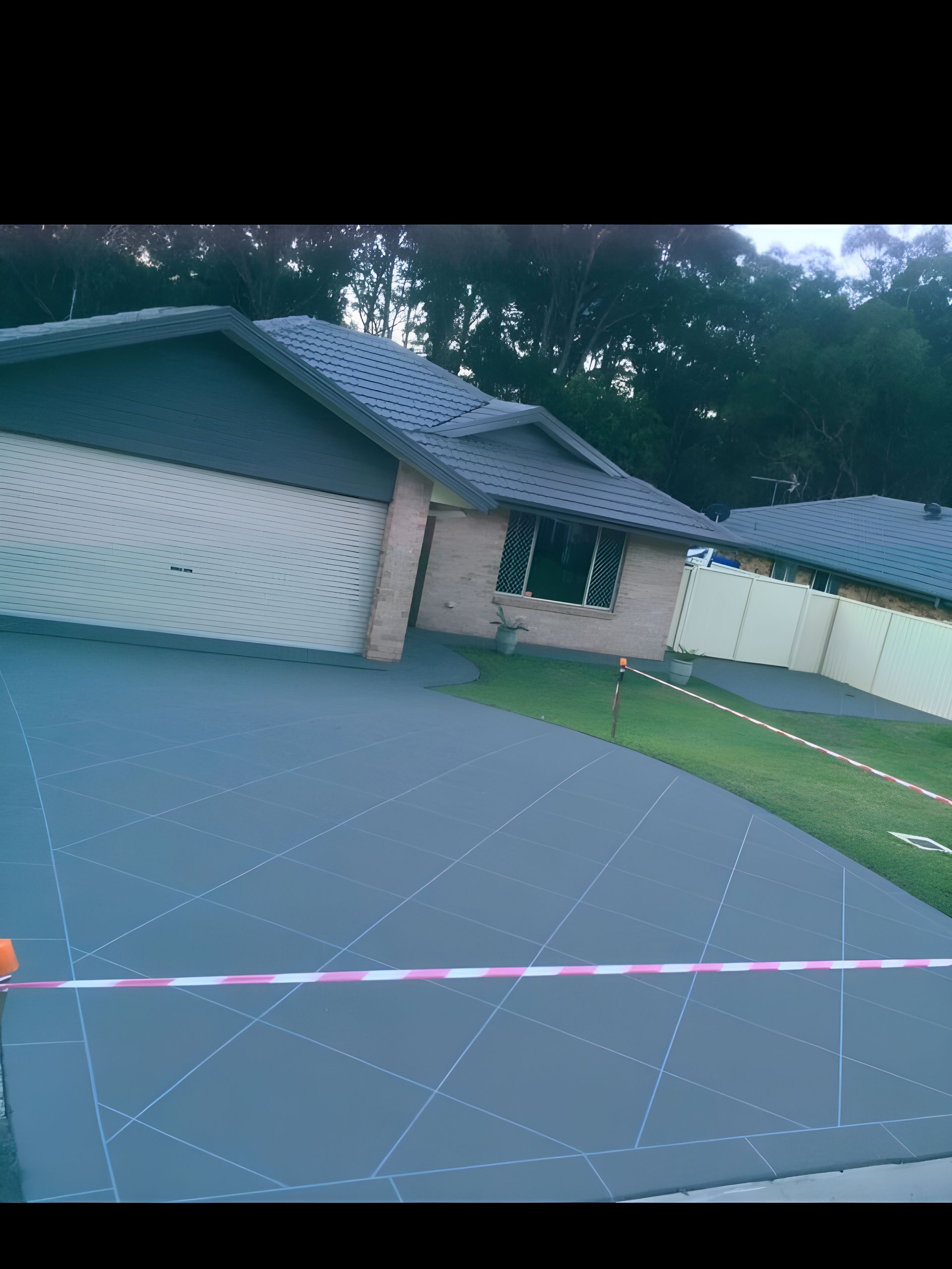 A House With A Garage And A Driveway In Front Of It — River2Coast Concreting in Boambee, NSW