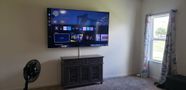 A living room with a large flat screen tv mounted on the wall.