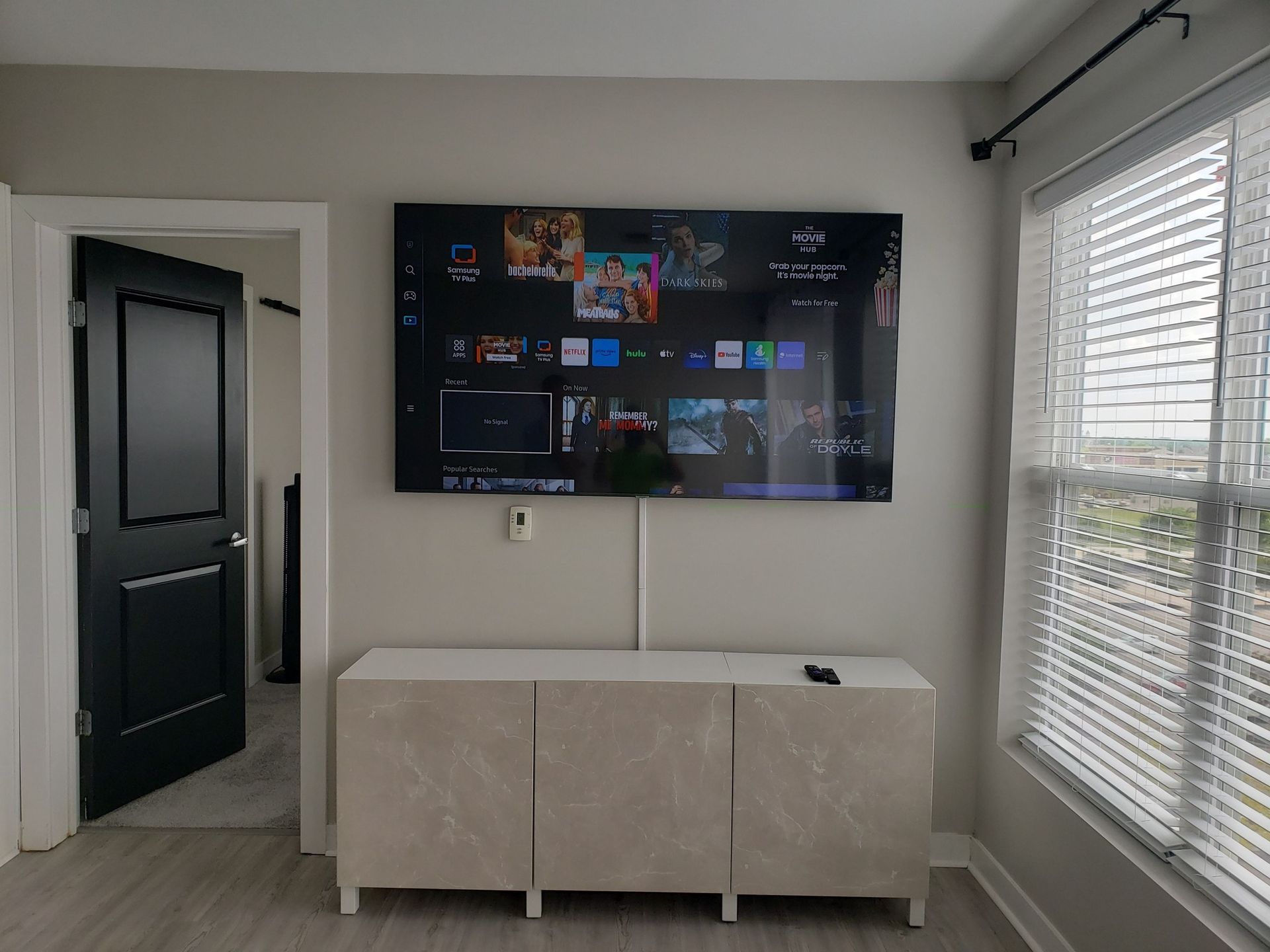 A living room with a flat screen tv mounted on the wall.