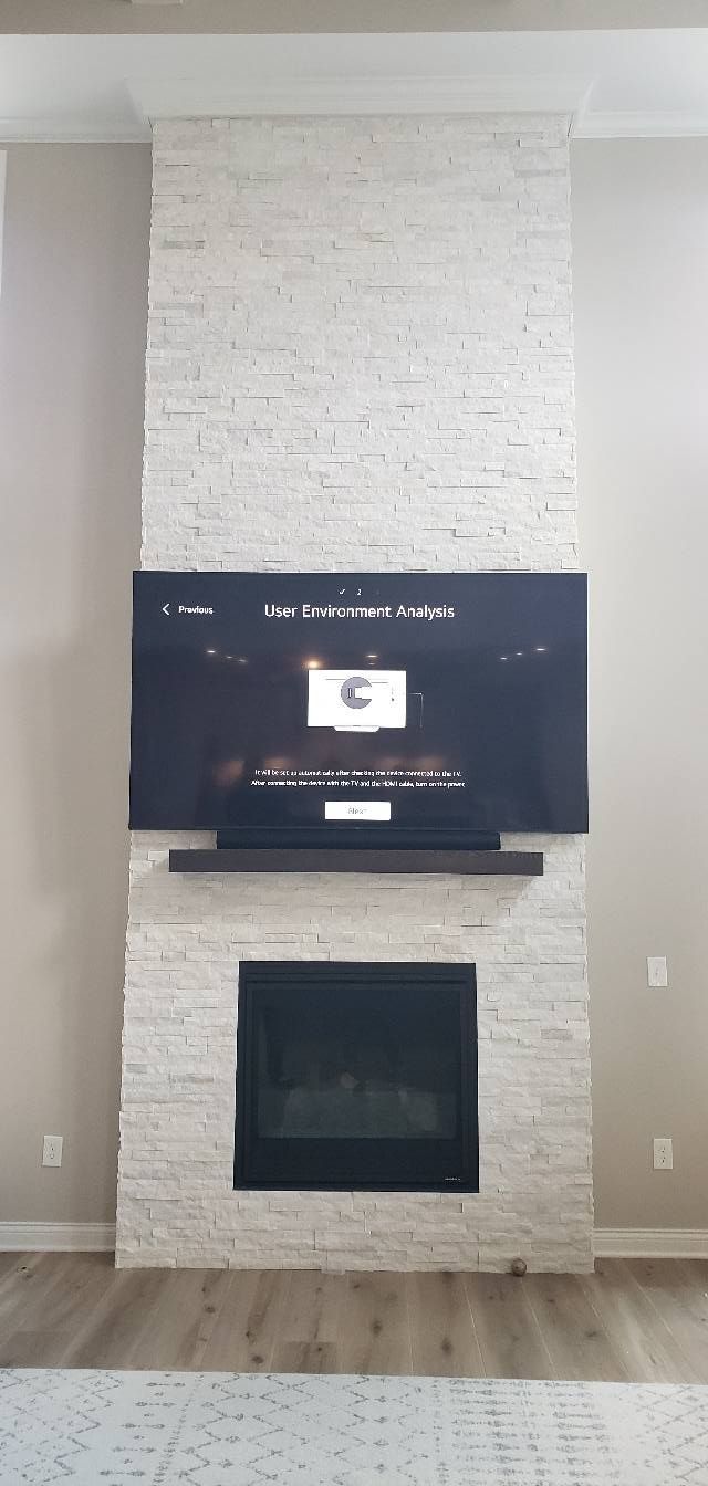 A living room with a fireplace and a flat screen tv mounted on the wall.