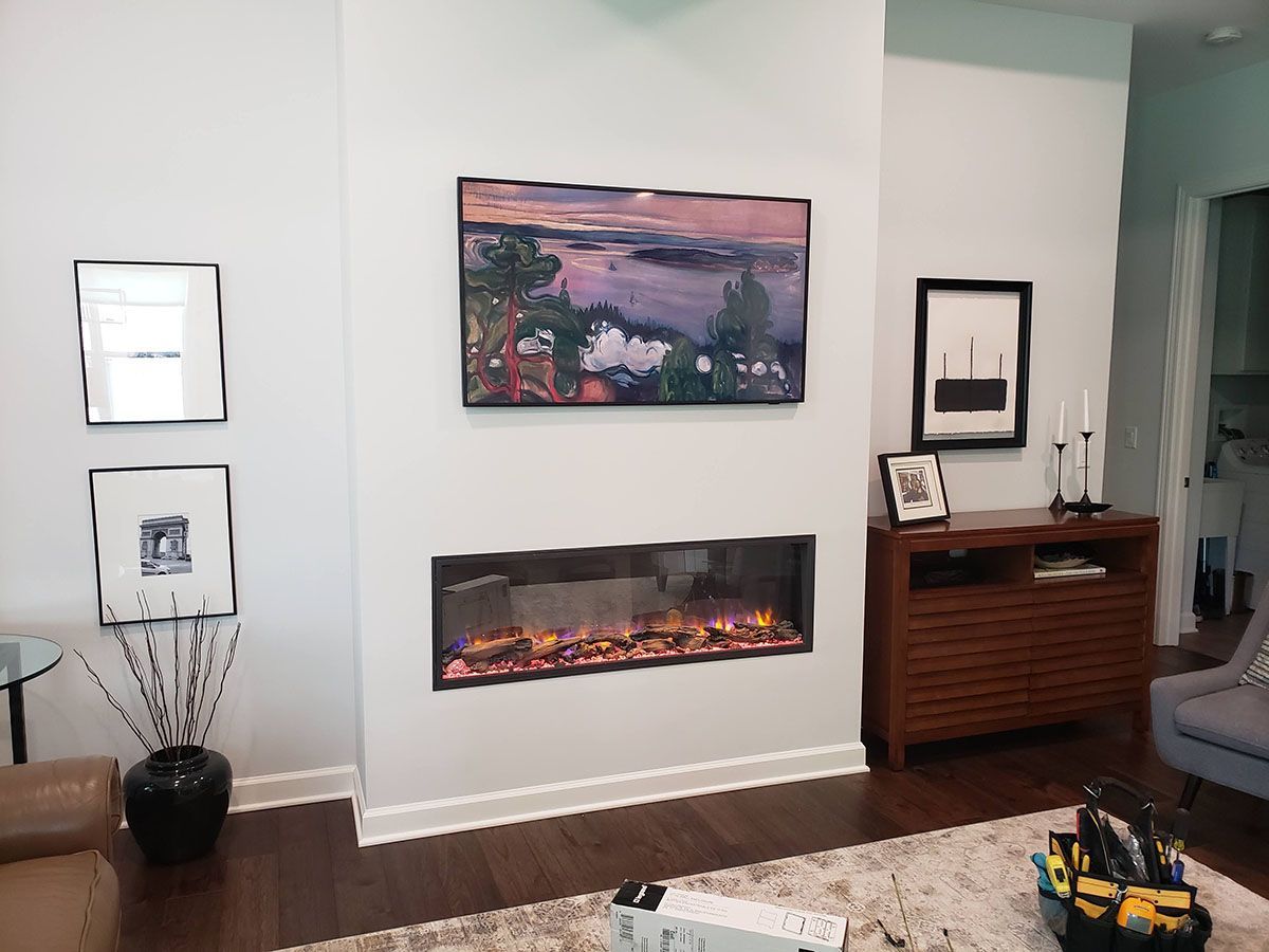 A living room with a fireplace and a flat screen tv on the wall.