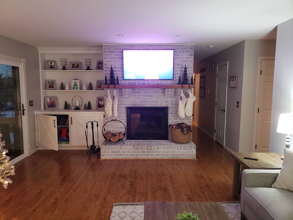 A living room with a fireplace and a flat screen tv.