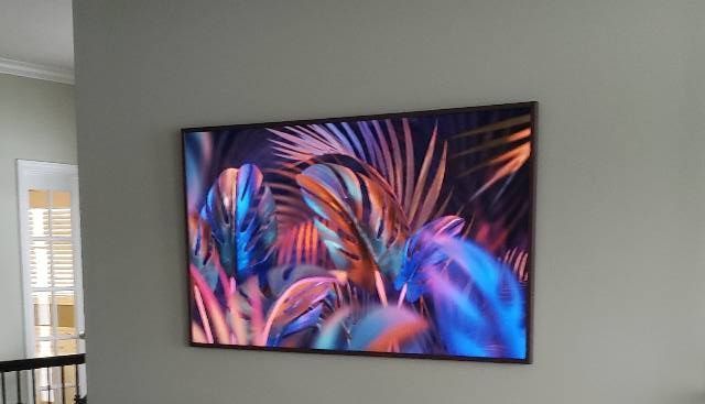 A painting of palm leaves is hanging on a wall