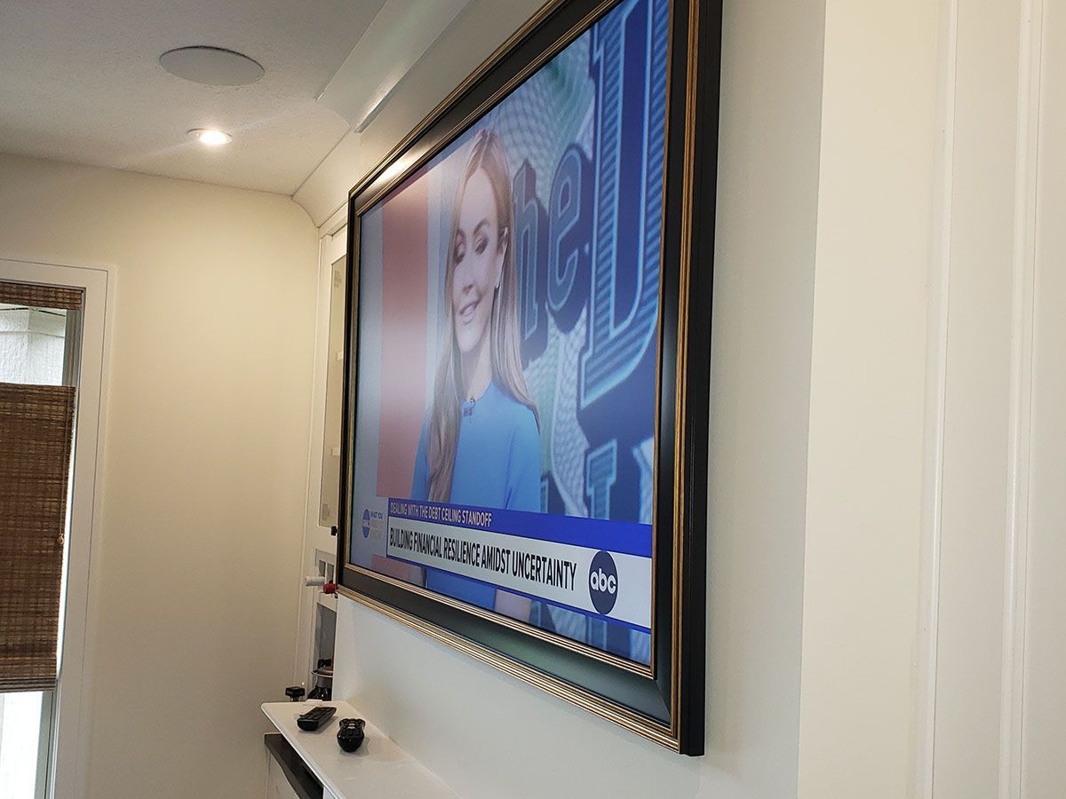 A large flat screen tv is hanging on a wall in a living room.