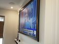 A large flat screen tv is hanging on a wall in a living room.