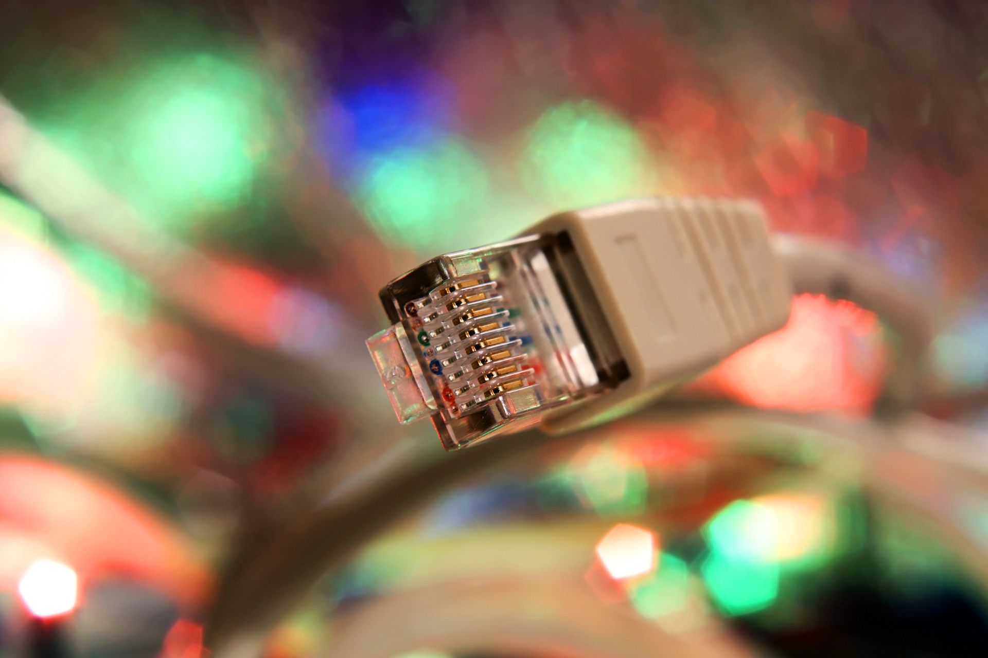 A close up of an ethernet cable with christmas lights in the background. A close up of an ethernet cable with christmas lights in the background.