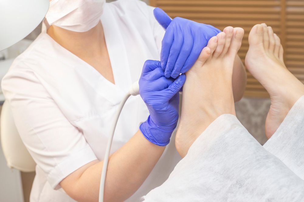 A Woman Is Giving A Foot Treatment To A Patient — HealthPoint Mingara In Tumbi Umbi, NSW