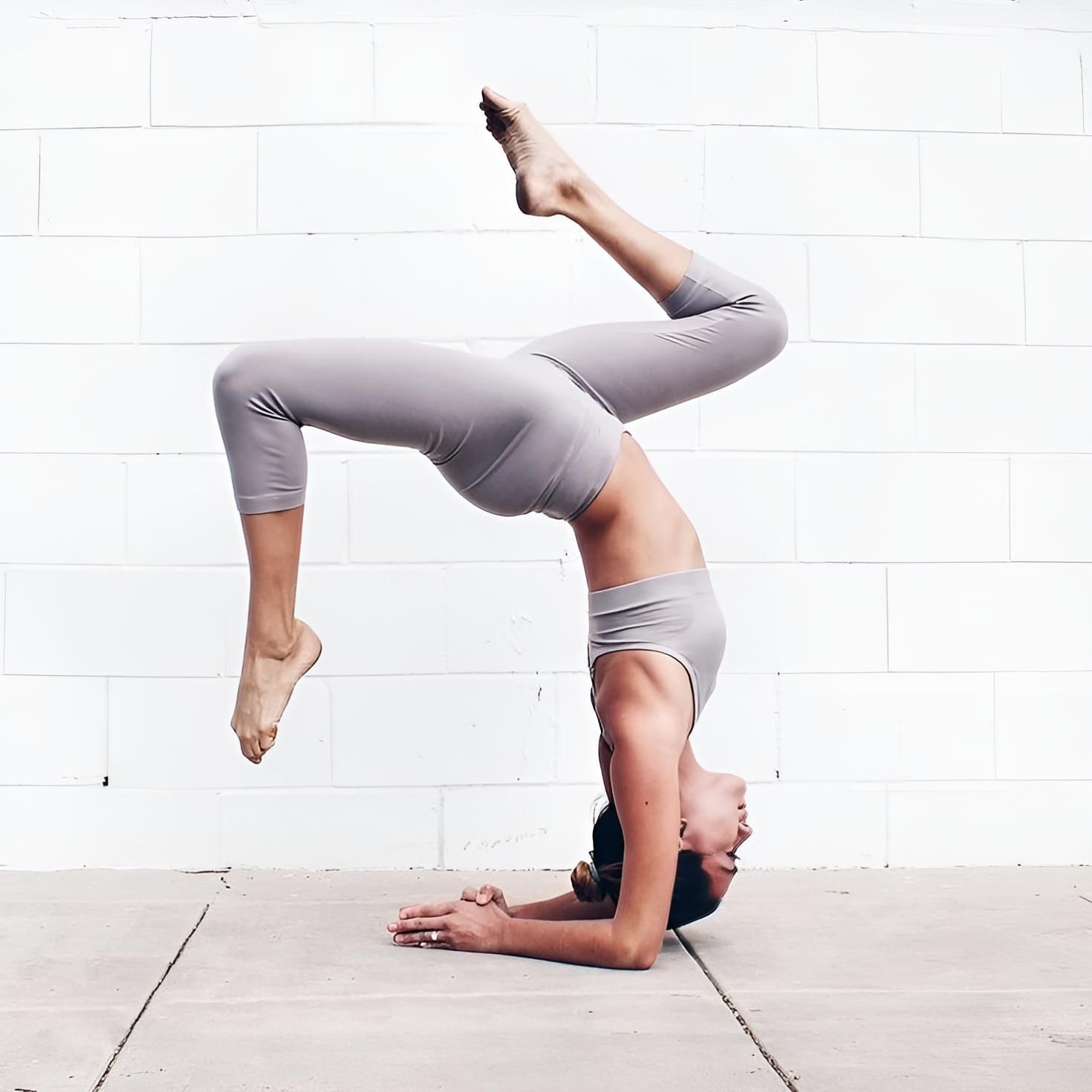 A Woman Is Doing A Handstand In Front Of A White Brick Wall — HealthPoint Mingara In Tumbi Umbi, NSW