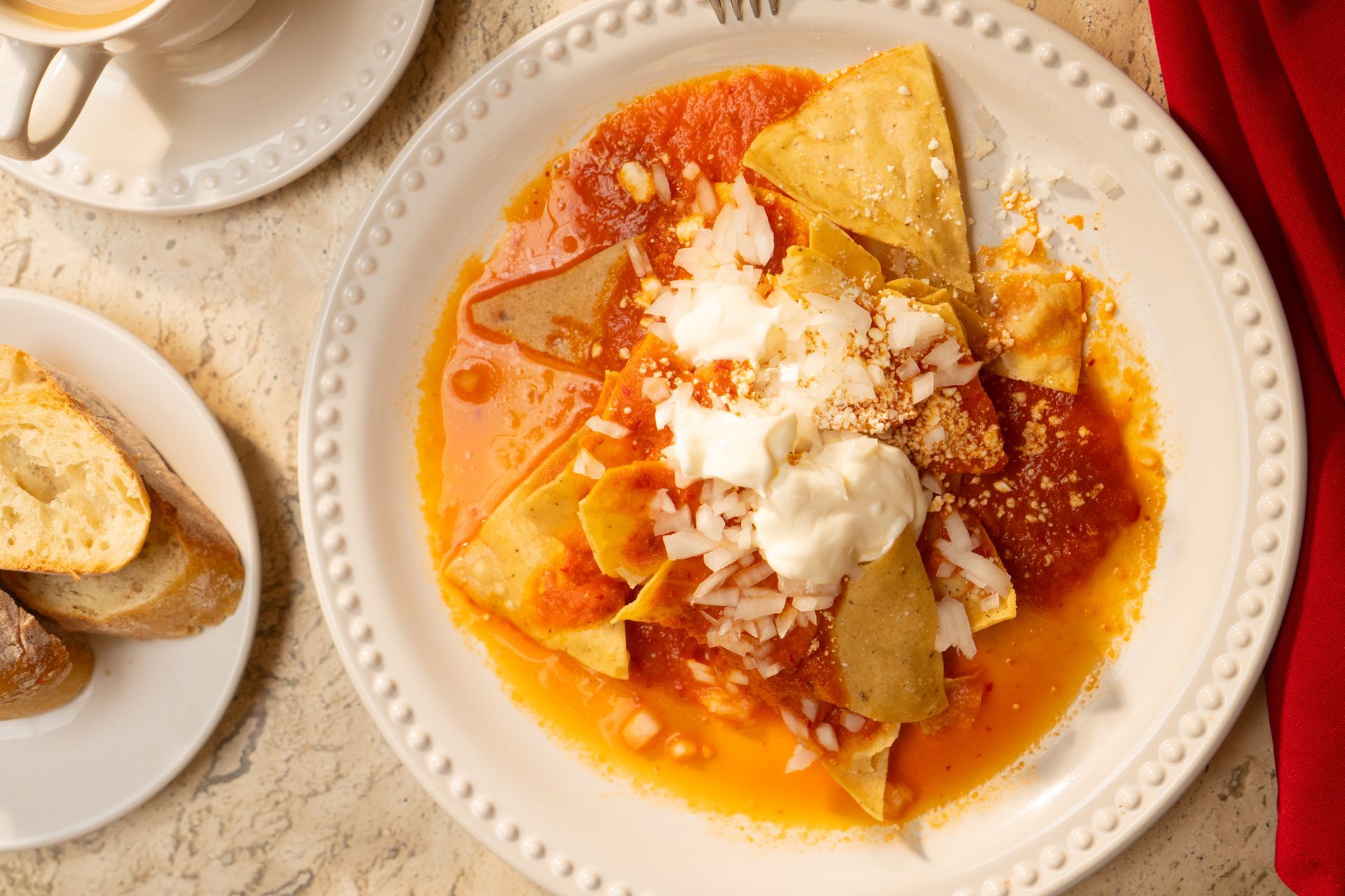 Dos panes planos doblados en un plato blanco sobre un mantel de rayas amarillas y blancas
