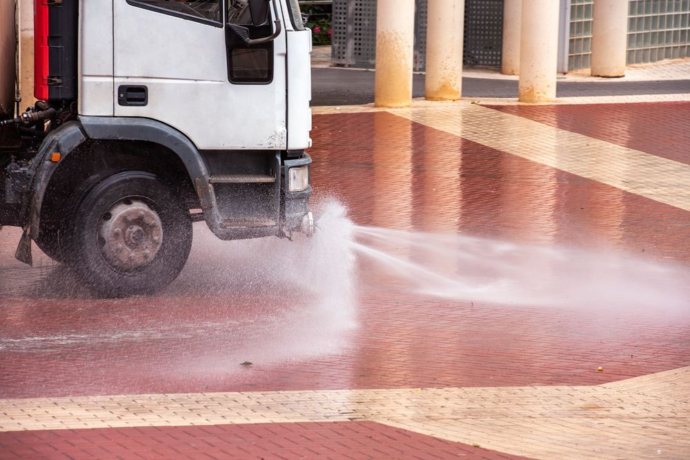 Truck Spraying Water Across a Brick-paved Plaza — Rainman Domestic Water In Childers, QLD