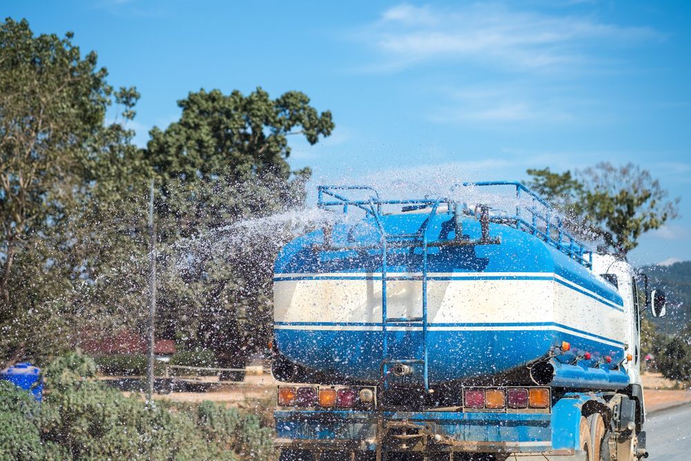 Blue and White Truck Spraying Water — Rainman Domestic Water In Moore Park, QLD