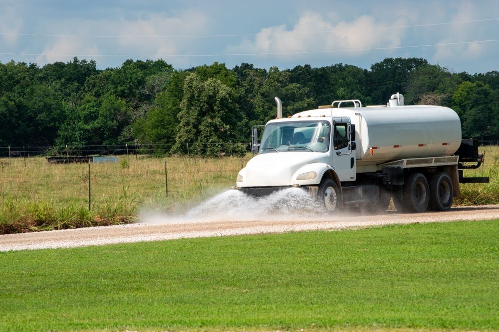 Tanker Truck Spraying Water on a Roadside — Rainman Domestic Water In Agnes Waters, QLD