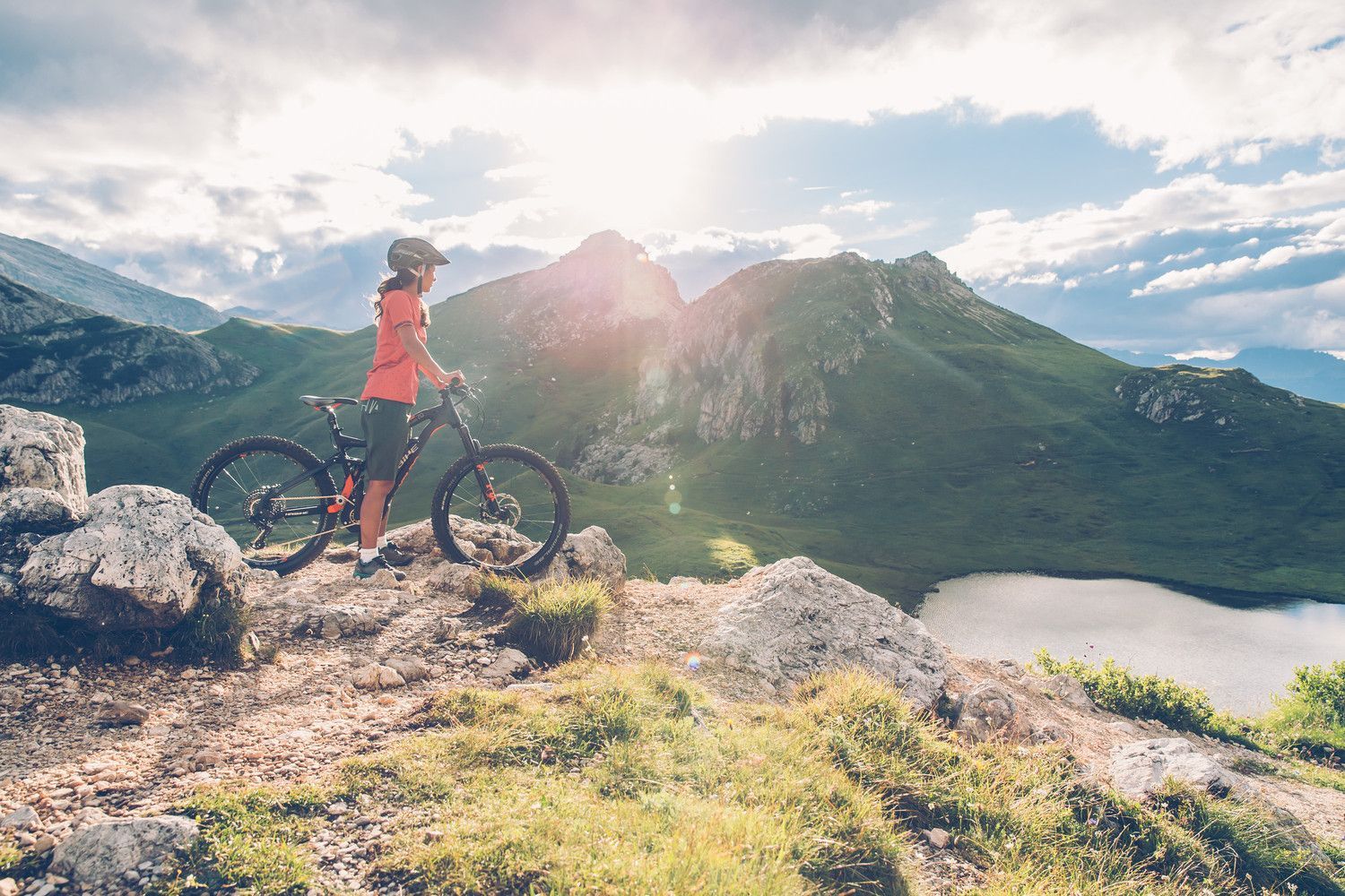 Mountainbikerin betrachtet einen Bergsee