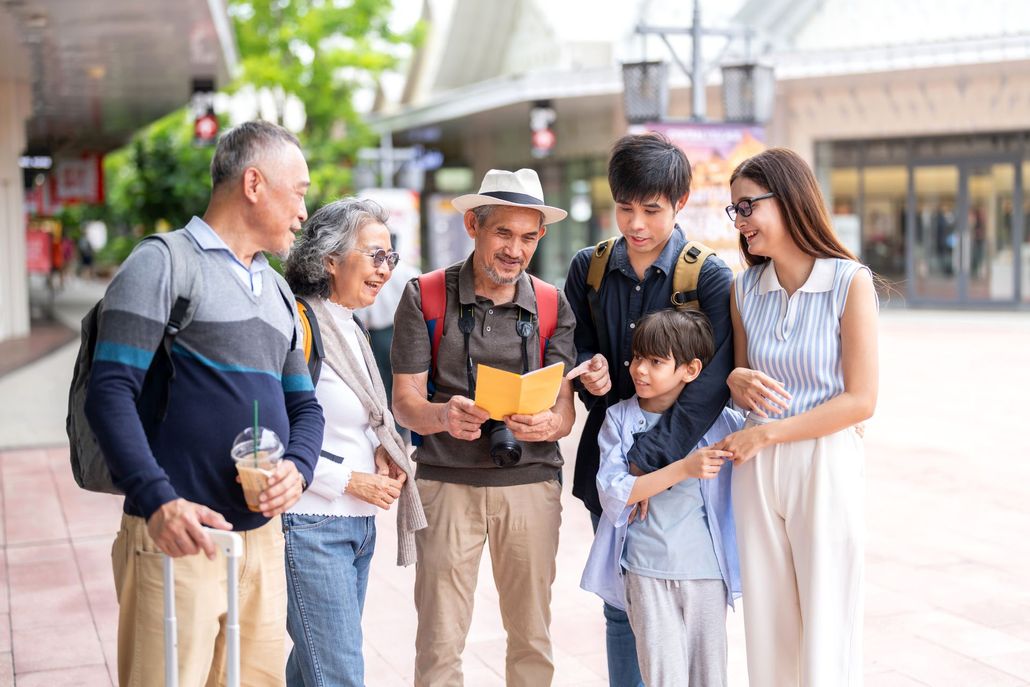 Family of six looking at a map outdoors, in a shopping area. Family of six looking at a map outdoors, in a shopping area.