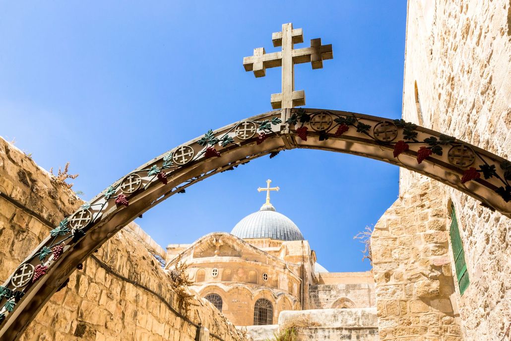 Archway with a stone cross, leading to a church with a blue dome in Jerusalem. Archway with a stone cross, leading to a church with a blue dome in Jerusalem.
