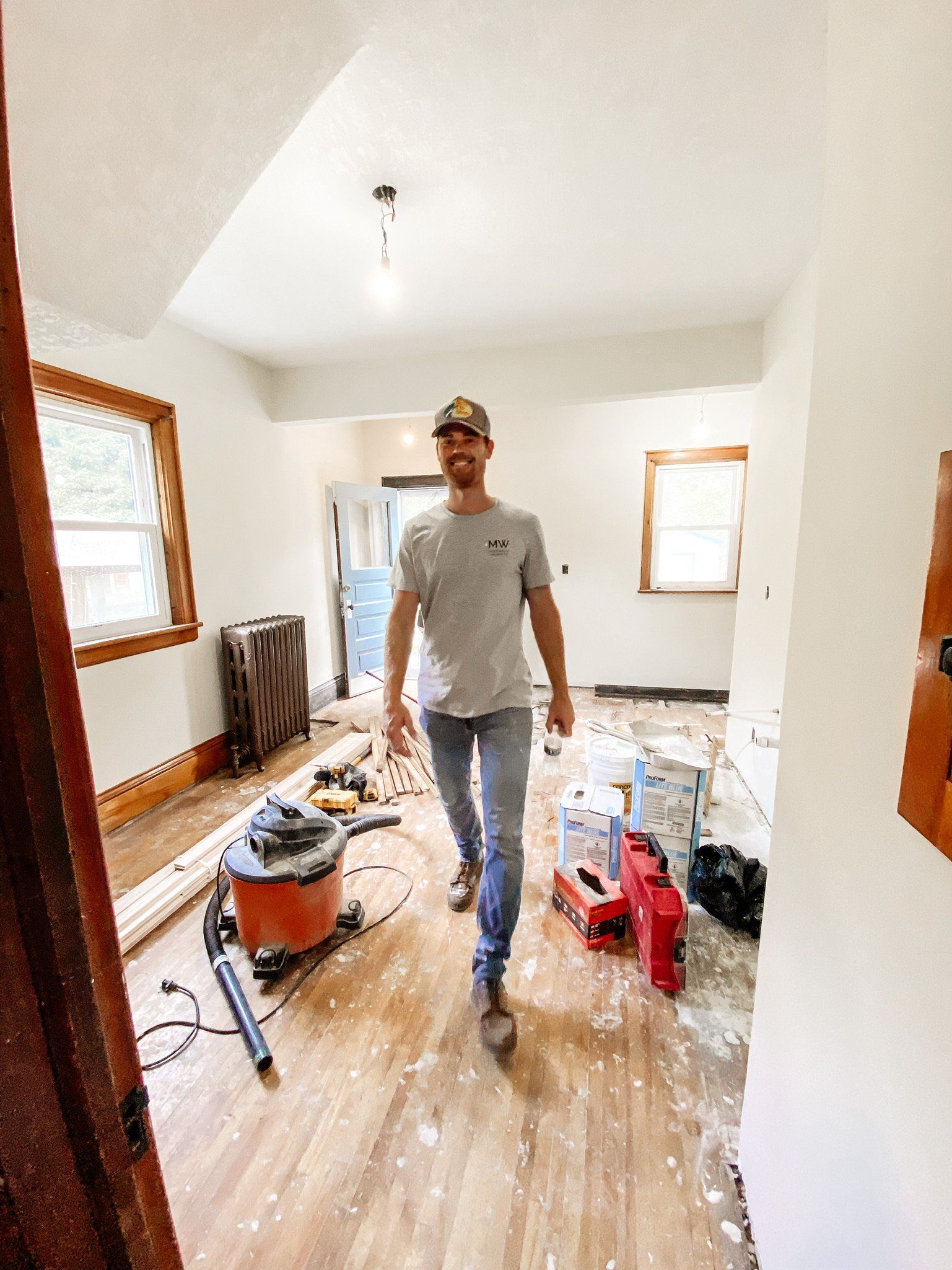 A man is walking through a room that is being remodeled.