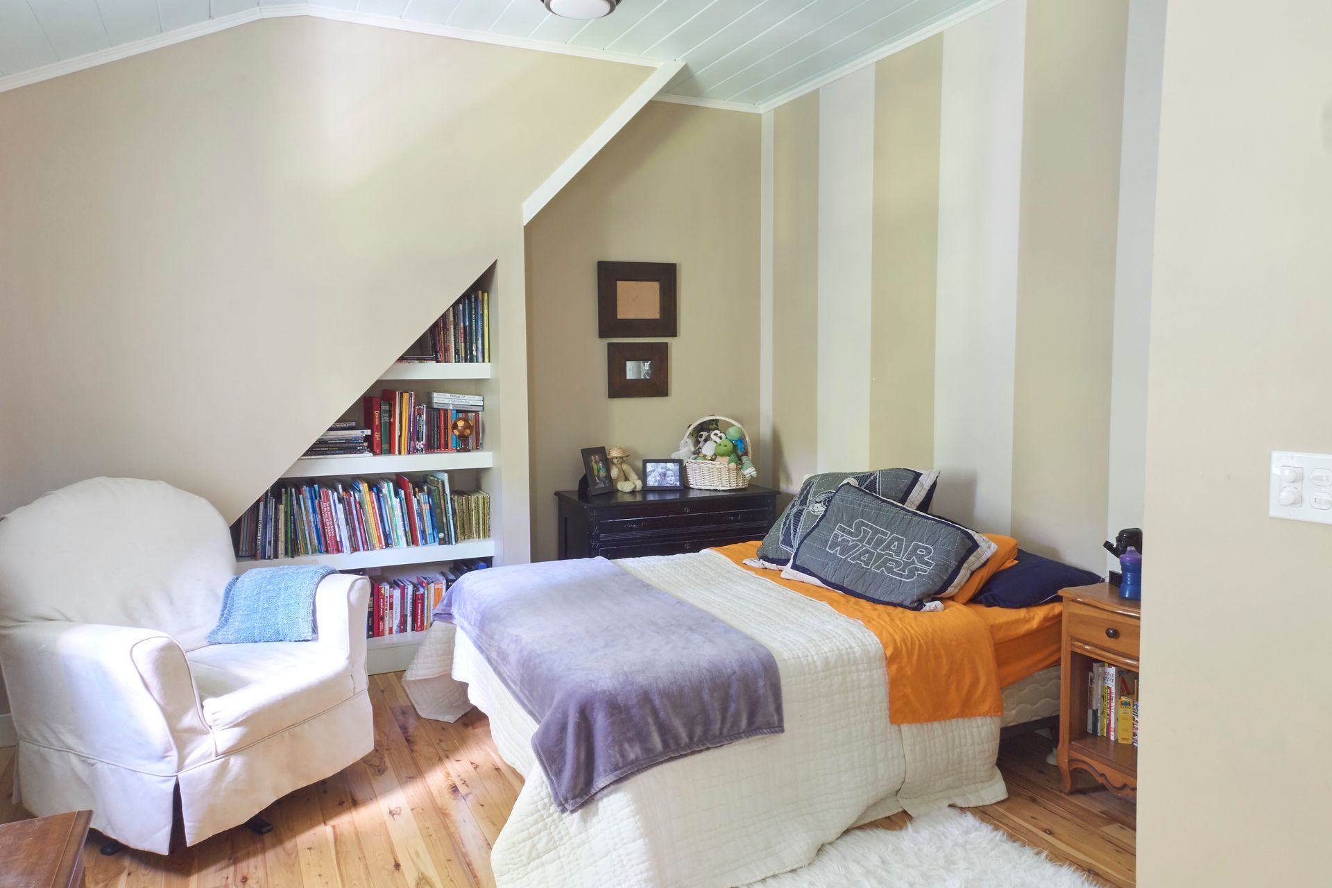 Whitecap Builders reconfigured attic space into a cozy guest bedroom with custom shelving in Waldo, Maine.