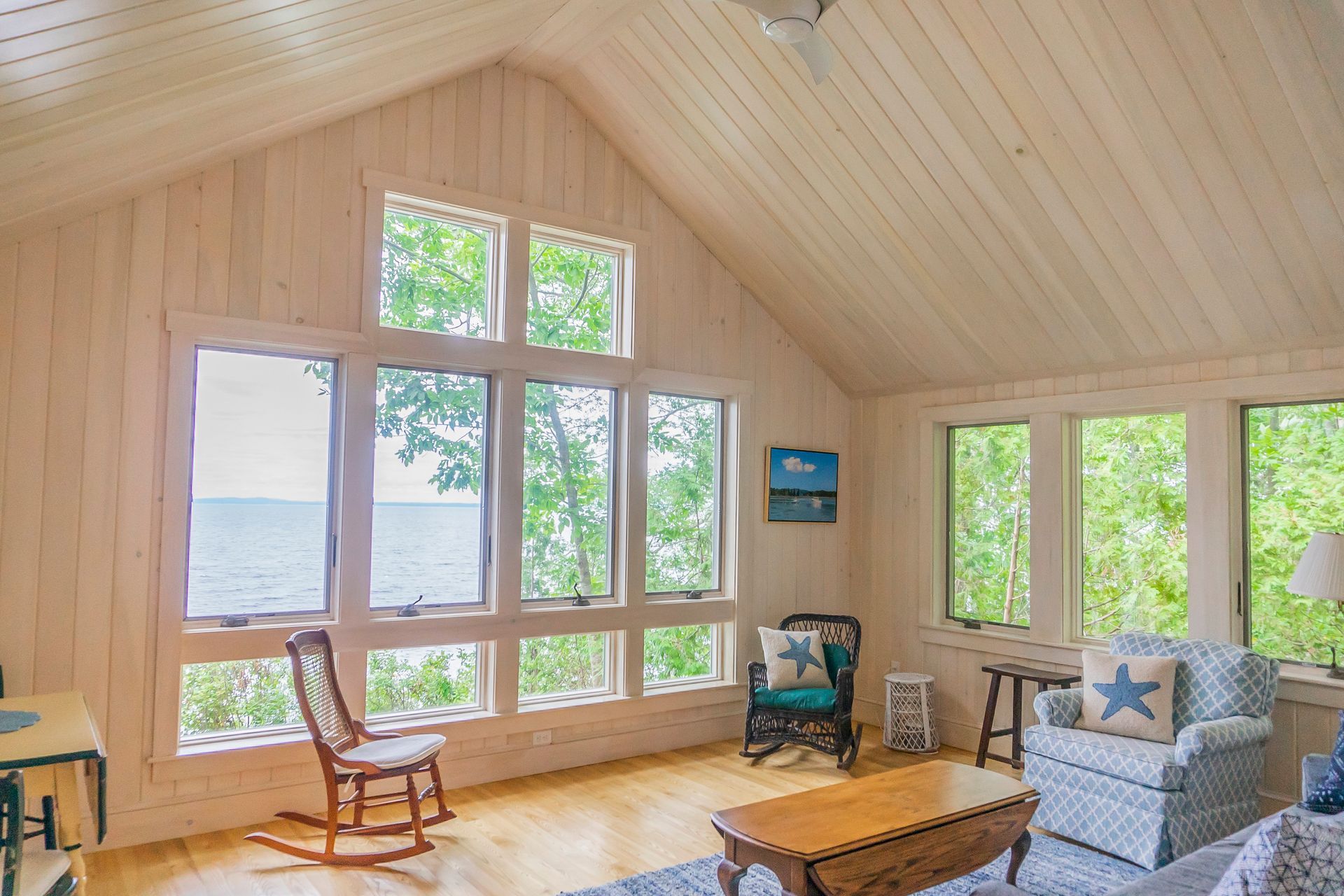 A living room with a lot of windows and a rocking chair