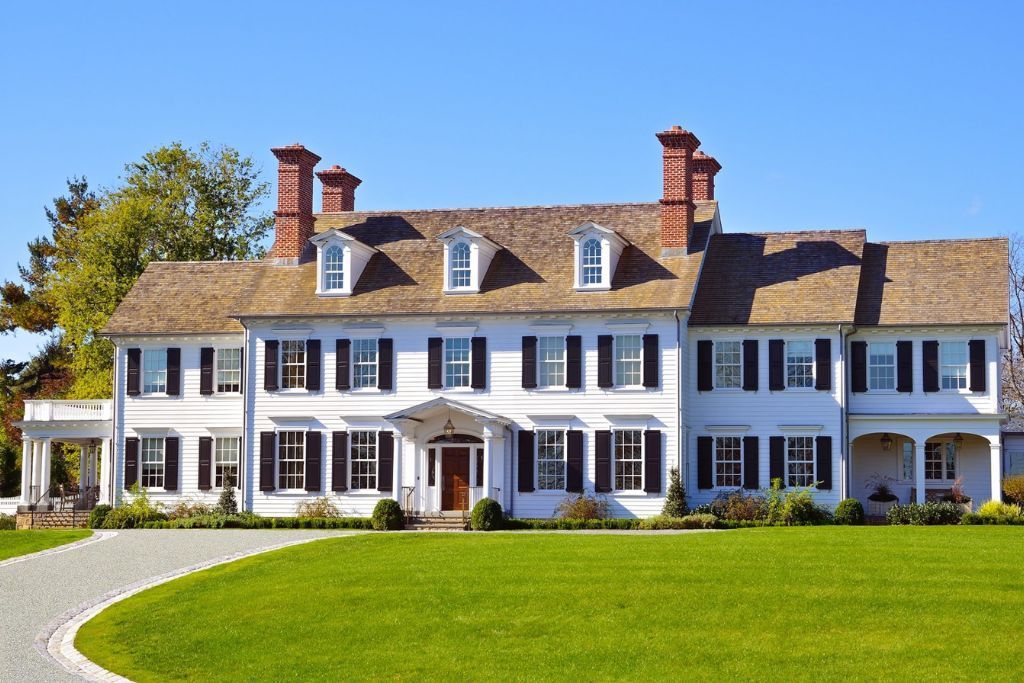 A large white house with a driveway leading to it
