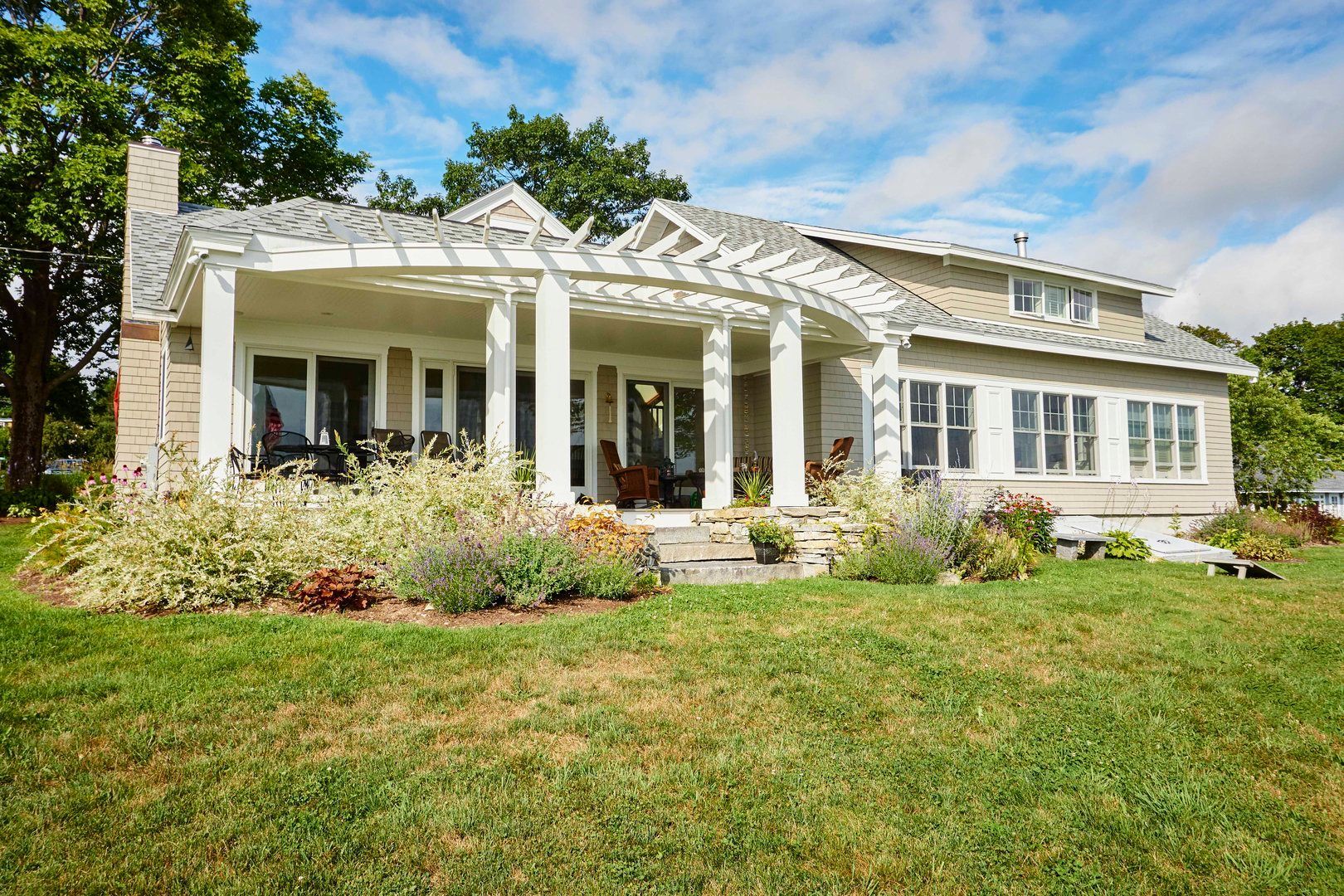 Whitecap Builders remodeled the exterior with a new front porch and landscaping in Northport, Maine.
