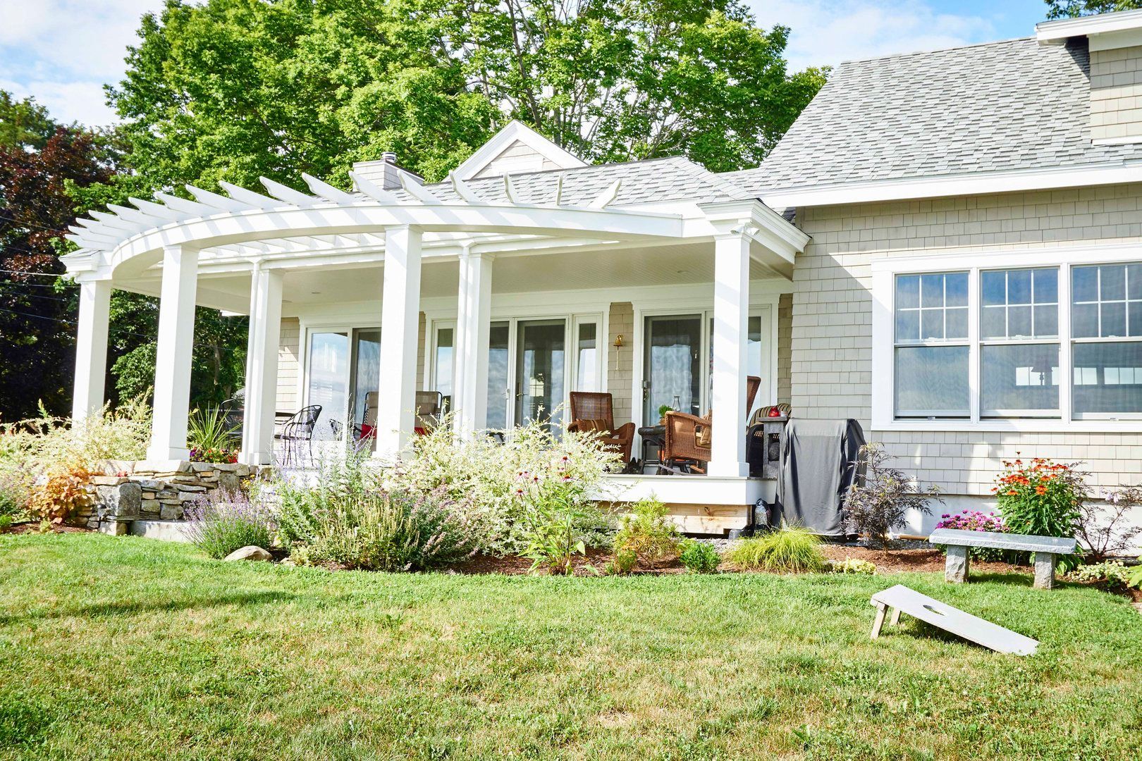 Whitecap Builders upgraded a backyard patio and added a sunroom for a family home in Searsport, Maine.